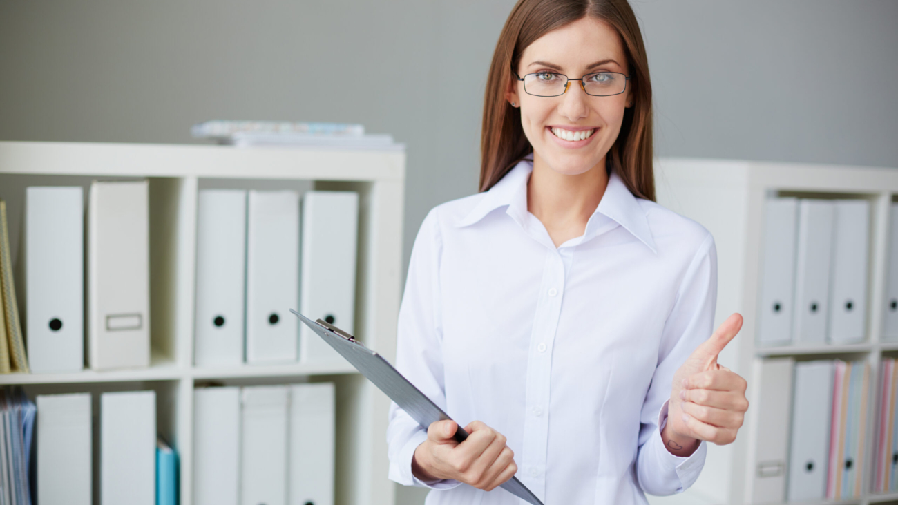 Young businesswoman with document showing thumb up